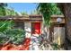 Charming home with mature landscaping, a red door, and a welcoming walkway at 2953 Yucca Ct, Palm Harbor, FL 34684