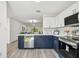 Modern kitchen with white cabinets, navy blue base, stainless steel appliances, and an open-concept layout at 2953 Yucca Ct, Palm Harbor, FL 34684