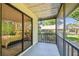 Cozy screened-in patio with a sliding door, offering views of the mature trees and surroundings at 2953 Yucca Ct, Palm Harbor, FL 34684