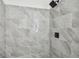 Close up of the shower showing gray marbled tile and black hardware at 2953 Yucca Ct, Palm Harbor, FL 34684
