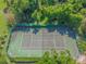 Aerial view of a tennis court bordered by vibrant greenery, providing a private and scenic playing experience at 2953 Yucca Ct, Palm Harbor, FL 34684