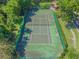 Aerial view of a well-maintained tennis court surrounded by lush greenery, offering a recreational amenity at 2953 Yucca Ct, Palm Harbor, FL 34684