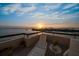 Relaxing balcony featuring comfortable lounge chairs with stunning sunset views overlooking calm waters at 4 Belleview Blvd # 802, Belleair, FL 33756