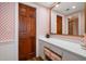Bathroom with vanity, drawers, mirror, and patterned wallpaper, with bifold door to bath/shower and another mirror at 4 Belleview Blvd # 802, Belleair, FL 33756