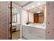 The bathroom features white cabinets, gold hardware, and a unique star pattern wallpaper at 4 Belleview Blvd # 802, Belleair, FL 33756