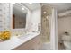 Bathroom features white vanity, floral wallpaper, and shower/tub combo at 4 Belleview Blvd # 802, Belleair, FL 33756