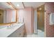 Bathroom featuring vanity, drawers, mirror, tub with shower and towel rack, and unique star pattern wallpaper at 4 Belleview Blvd # 802, Belleair, FL 33756