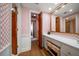 Bathroom with vanity, drawers, mirror, and patterned wallpaper, with bifold door to bedroom beyond at 4 Belleview Blvd # 802, Belleair, FL 33756
