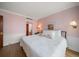 Inviting bedroom featuring hardwood floors, crown molding, and a comfortable bed with patterned floral pillows at 4 Belleview Blvd # 802, Belleair, FL 33756