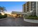 The entrance to the building on a brick drive, under a modern awning with manicured landscaping at 4 Belleview Blvd # 802, Belleair, FL 33756