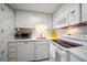 Bright kitchen features white cabinetry, updated appliances, and a neutral countertop at 4 Belleview Blvd # 802, Belleair, FL 33756