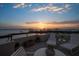 Beautiful rooftop terrace with lounge chairs overlooking the water during a colorful sunset at 4 Belleview Blvd # 802, Belleair, FL 33756