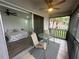 View from balcony shows table and chairs overlooking green space, with a glimpse into bedroom with butterfly patterned bedding at 4022 Cortez Dr # A, Tampa, FL 33614