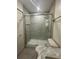 A bathroom with a large glass enclosed shower, updated fixtures, gray tiles, and marble vanity top at 4022 Cortez Dr # A, Tampa, FL 33614