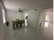 Dining area with green table set, ceiling fan, and white tile floors that transition to the living room at 4022 Cortez Dr # A, Tampa, FL 33614