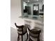 Kitchen bar with two stools and a view of the modern kitchen and dining area at 4022 Cortez Dr # A, Tampa, FL 33614