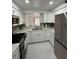 Modern kitchen featuring white cabinets, stainless steel appliances, tile backsplash, and tile floors at 4022 Cortez Dr # A, Tampa, FL 33614