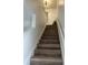 A bright stairway with modern wooden steps, freshly painted white walls, and a contemporary light fixture leading to the upper level at 4022 Cortez Dr # A, Tampa, FL 33614