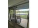 View from inside shows the balcony with seating area and a scenic view of a lake and greenery beyond at 4022 Cortez Dr # A, Tampa, FL 33614