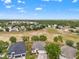 Spacious neighborhood with well-maintained homes and landscaping, set against a backdrop of green trees and fields at 4214 Canongate Ct, Spring Hill, FL 34609