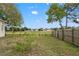 Spacious backyard with lush green grass enclosed by a classic picket fence at 4214 Canongate Ct, Spring Hill, FL 34609