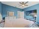 Bright bedroom featuring blue walls, ceiling fan, television and ample closet space at 4214 Canongate Ct, Spring Hill, FL 34609