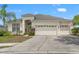 Inviting one-story home featuring a three-car garage, lush landscaping, and a well-manicured lawn at 4214 Canongate Ct, Spring Hill, FL 34609