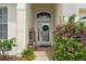 Charming entryway with decorative plants and a glass front door, enhanced by a wreath and unique décor at 4214 Canongate Ct, Spring Hill, FL 34609