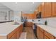 Modern kitchen with wood cabinetry, stainless steel appliances, and a breakfast bar overlooking living area at 4214 Canongate Ct, Spring Hill, FL 34609