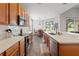 Well-lit kitchen featuring stainless steel appliances, wood cabinets, and white countertops, open to dining area at 4214 Canongate Ct, Spring Hill, FL 34609