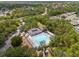 Aerial view of a community pool and clubhouse surrounded by trees and houses at 4214 Canongate Ct, Spring Hill, FL 34609