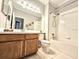 Functional bathroom with oak vanity, white tile, and shower-tub combo for convenience at 4214 Canongate Ct, Spring Hill, FL 34609