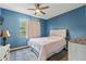 Cozy bedroom with ceiling fan, large window and blue accent wall at 4214 Canongate Ct, Spring Hill, FL 34609