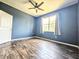 This spacious bedroom has a ceiling fan, wood floors, and natural light at 4214 Canongate Ct, Spring Hill, FL 34609
