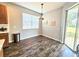 Dining area featuring modern chandelier, wood floors, sliding glass doors, and a view of the backyard at 4214 Canongate Ct, Spring Hill, FL 34609