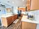 Bright kitchen featuring wood cabinets, stainless steel appliances, and white countertops with a view into the living area at 4214 Canongate Ct, Spring Hill, FL 34609