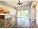 Open living room featuring wood floors, vaulted ceiling, and sliding glass doors leading to an outdoor patio at 4214 Canongate Ct, Spring Hill, FL 34609