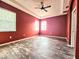 Primary bedroom featuring tray ceiling, wood-look floors, and a double window view of the backyard at 4214 Canongate Ct, Spring Hill, FL 34609