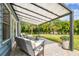 Shaded backyard patio with cozy seating, overlooking the lush green lawn and serene landscaping at 4403 W Bay Court Ave, Tampa, FL 33611