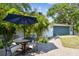 This backyard living space has an outdoor table, mature landscaping, and a private fenced yard at 4403 W Bay Court Ave, Tampa, FL 33611