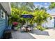 Seating area of a fully fenced backyard with manicured landscaping, and mature trees at 4403 W Bay Court Ave, Tampa, FL 33611