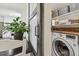 Convenient laundry room with modern washer/dryer, wooden countertop, and stylish baskets for storage, accessible from kitchen at 4403 W Bay Court Ave, Tampa, FL 33611