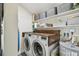 Functional laundry room features a modern washer/dryer, wooden countertop, and ample storage shelves with stylish baskets at 4403 W Bay Court Ave, Tampa, FL 33611