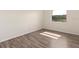 A bright, empty bedroom featuring a hardwood floor and a window to bring the natural lighting inside at 533 E Curlew Pl # 533, Tarpon Springs, FL 34689