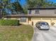 Two-story home with brick and wood exterior, two car garage, and a well-maintained front yard at 533 E Curlew Pl # 533, Tarpon Springs, FL 34689