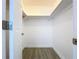 Walk-in closet featuring wooden floors, lighting, and extra vertical storage space for optimal organization at 5806 Liverpool Dr, Tampa, FL 33615