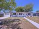 Charming single-story home with a white painted brick facade, attached garage, and simple, tidy landscaping at 5806 Liverpool Dr, Tampa, FL 33615
