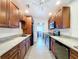 Galley kitchen featuring wood cabinets, granite counters, stainless appliances, and tile flooring at 5806 Liverpool Dr, Tampa, FL 33615
