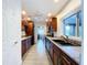 Galley kitchen featuring wood cabinets, granite counters, stainless appliances, and tile flooring at 5806 Liverpool Dr, Tampa, FL 33615
