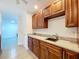 A kitchen area featuring wooden cabinets, marble countertops, stainless steel appliances, and modern fixtures at 5806 Liverpool Dr, Tampa, FL 33615